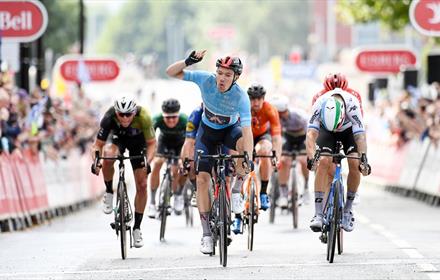 Ethan Hayter wins in cycle race in Warrington  with spectators both sides of road.