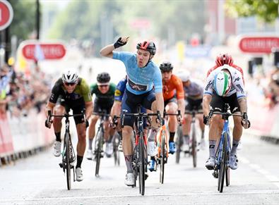 Ethan Hayter wins in cycle race in Warrington  with spectators both sides of road.