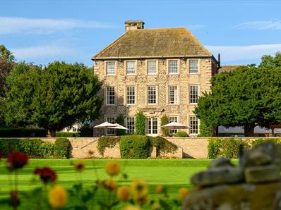 Exterior view of Headlam Hall, blue skies with gardens in foreground.