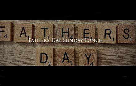 Scrabble letters spelling 'Father's day' underneath the white text in capital letters 'Father's Day Sunday Lunch'