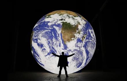 Large model of the earth with man standing in front.  Image credit: Natural Environment Research Council (NERC)

