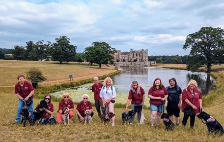 The Great British Dog Walk at Raby Castle.  Men and women with dogs in front of the lake and Raby Castle