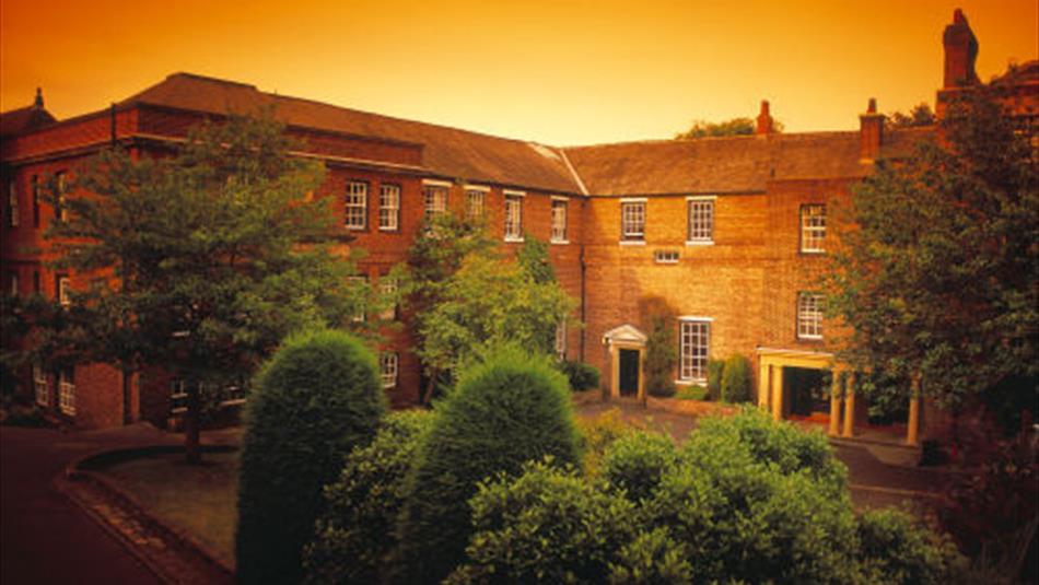 View of the exterior of Hatfield College with trees in the foreground