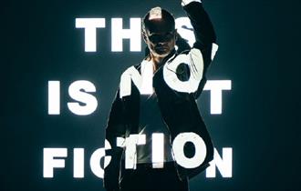 Image of a person with the words, 'This is not fiction' projected onto them.