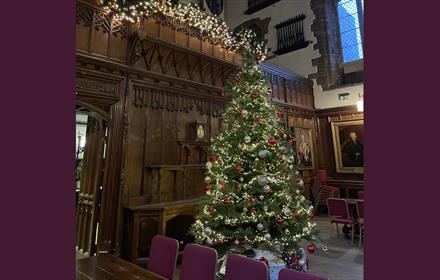 Decorated Christmas Tree lit with fairy lights.  Christmas garland. Durham Castle Great Hall
