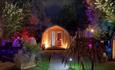 Camping pods lit up at night