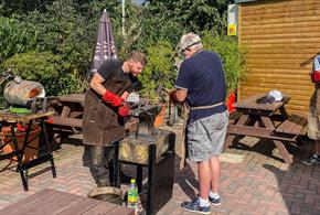 Blacksmith Workshops at South Causey Inn. People enjoying the workshop on a sunny day.