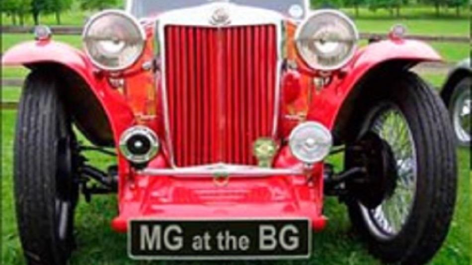 Close up of a red MG classic car, with a number plate that reads, 'MG at the BG'.