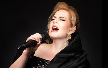 Close up photo of Natalie Black as Adele singing.