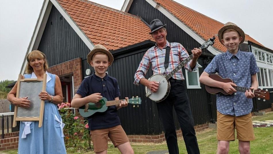 A family of musicians standing outside of Beamish Welfare Hall.