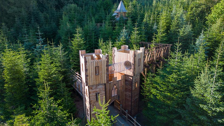 Drone shot of the Plotters' Forest Outdoor Adventure Playground surrounded by green fir trees