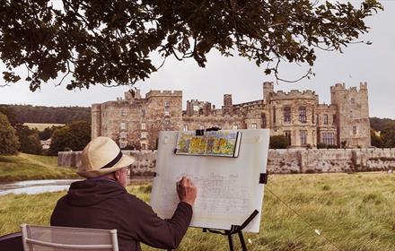 A man sitting and sketching Raby Castle