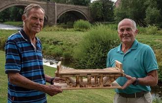 Photograph of Ralfe and Bob holding an artefact that they've recovered from the river.