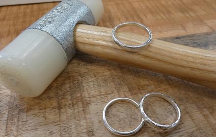 Image of newly made silver rings next to ring making tools.
