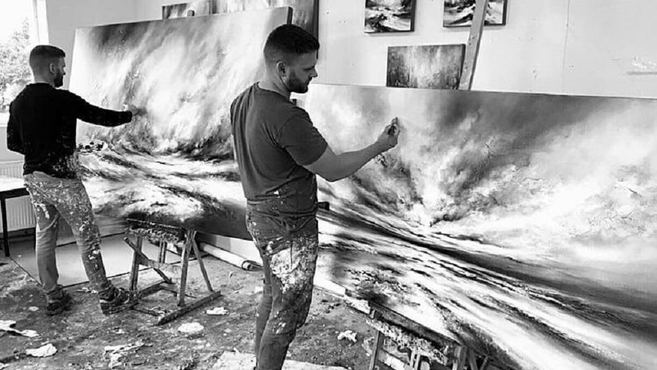 Black and white image of Chris and Steve Rocks painting in studio