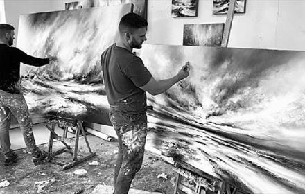 Black and white image of Chris and Steve Rocks painting in studio