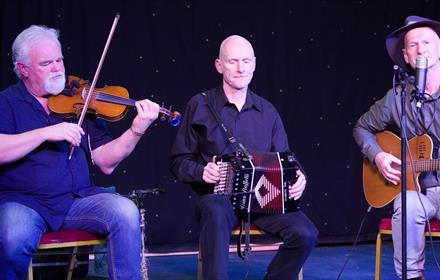 Photo of 3 members of Ceili Band playing instruments