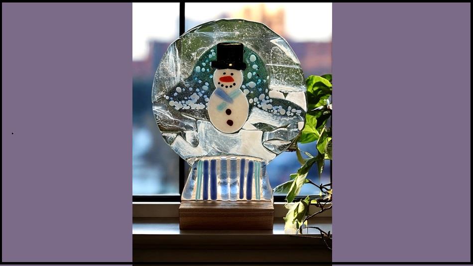 Fused glassed made into the shape of a snow globe with a Snowman design. Fused glassed made into the shape of a snow globe with a Snowman design.