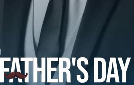 Zoomed in image of someone's tie, shirt and suit jacket. The words 'father's day' written in white capital letters. A moustache graphic crossing the f