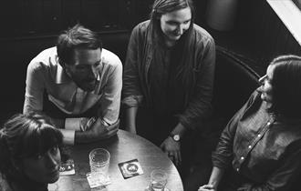 Photo of four members of The Furrow Collective sitting round table in pub
