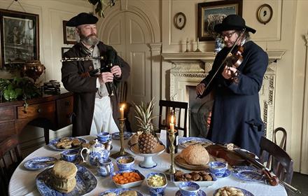 Musicians playing behind a table of festive food at Beamish Museum