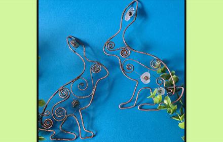 Copper hares with swirls and sea glass.