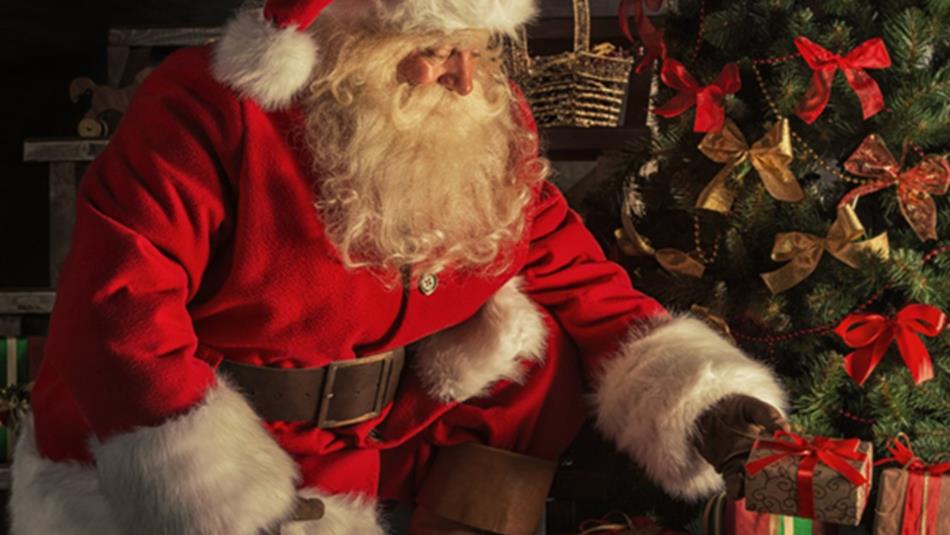 Santa placing presents under the tree. Santa placing presents under the tree.