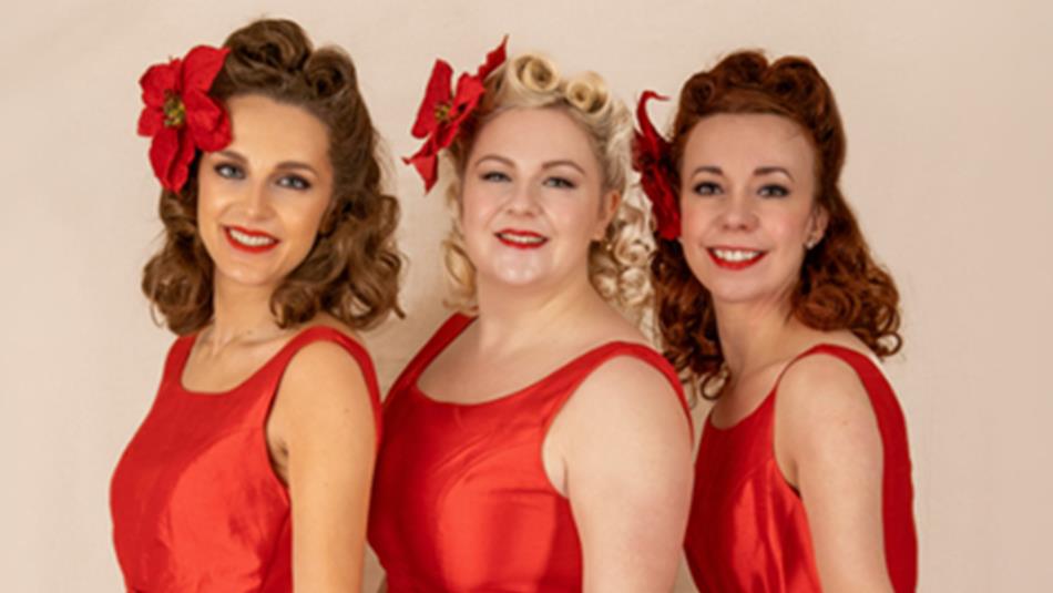 The Darling Dollies posing for a photo in red vintage dresses with vintage hair and makeup. The Darling Dollies posing for a photo in red vintage dresses with vintage hair and makeup.