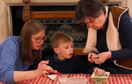 Image of 2 adults and a child enjoying crafting at Ushaw.