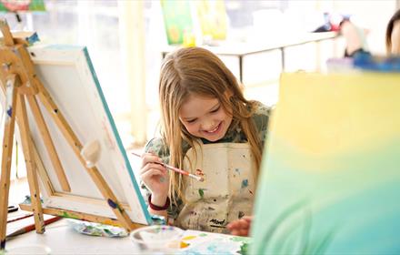 Image of little girl enjoying painting.