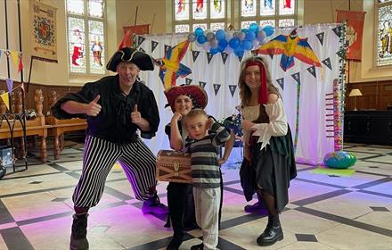 Two adults and two children dressed as pirates.