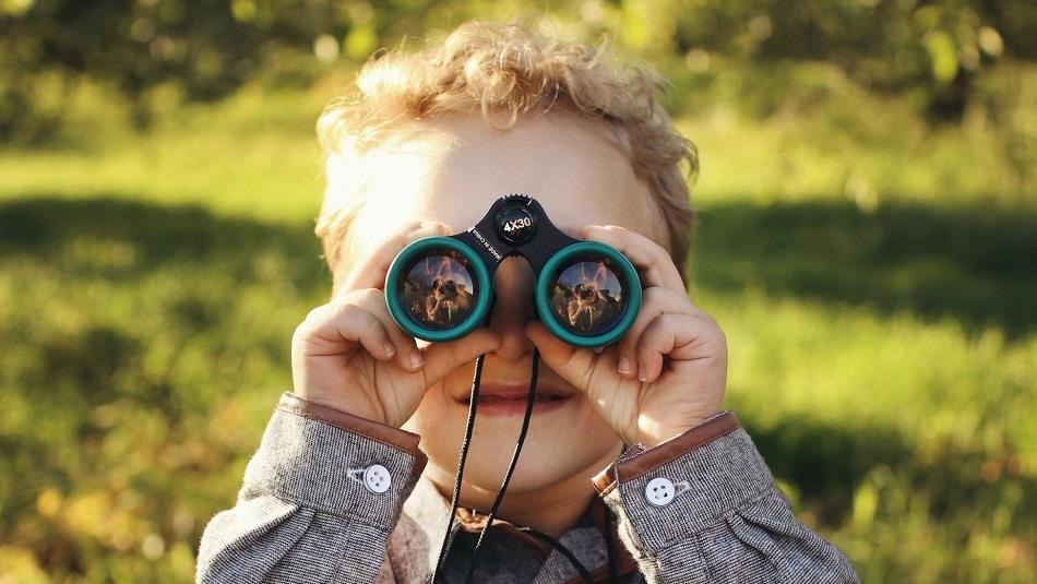 Child looking through binoculars.