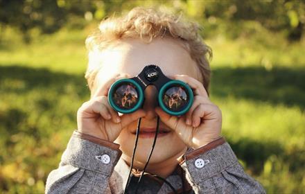 Child looking through binoculars.