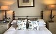 Double bed, cushions, bedside cabinets with lamps, picture