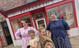 Image of people wearing 1950s hair and makeup outside The 1950s hairdresser's.