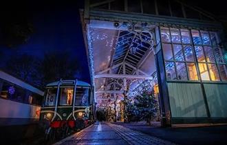 A train waiting at the platform of Weardale Railway, Fairy lights and Christmas Trees on platform