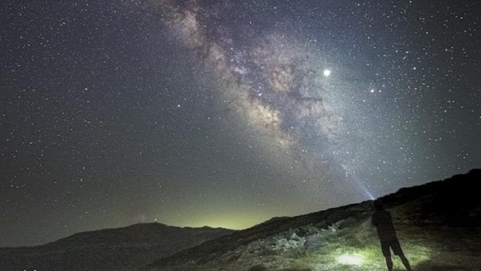 Image of someone stargazing outdoors in the countryside on a beautifully clear night.