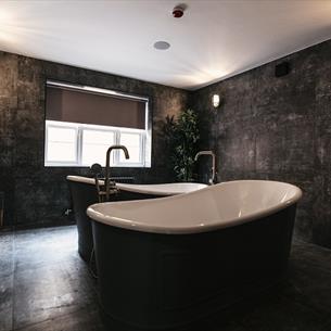 Bull Dog Suite at South Causey Inn. Image of a luxurious bathroom with double free-standing baths. 