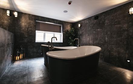 Bull Dog Suite at South Causey Inn. Image of a luxurious bathroom with double free-standing baths.