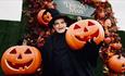 Spooky warlock at the entrance of the DreamMaze, surrounded by pumpkins.