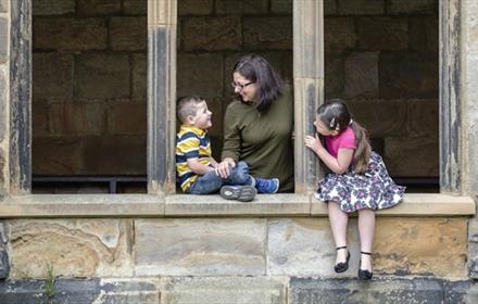 Family sat in the cloisters at Durham Cathedral Museum Family Fun Trail