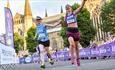 Female runners crossing the finish line of the Durham City Run