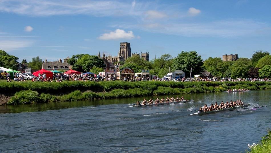 Image of The Men's Boat Race at Durham Regatta on a sunny day with the cathedral in the background.