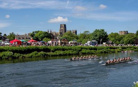 Image of The Men's Boat Race at Durham Regatta on a sunny day with the cathedral in the background.