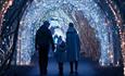 Family walking through tunnel of lights