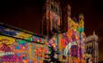 Durham Cathedral exterior at night, lit with colourful images of the Lindisfarne Gospels.