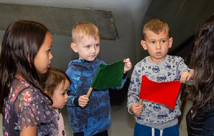 Image of four children holding flags and enjoying a 'Little Locos' session at Locomotion.