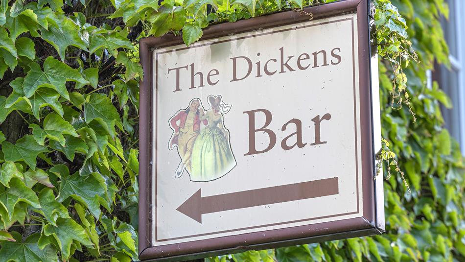 A sign saying The Dickens Bar
