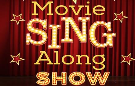 Text reads, 'Movie Sing Along Show' against a background of a theatre curtain.