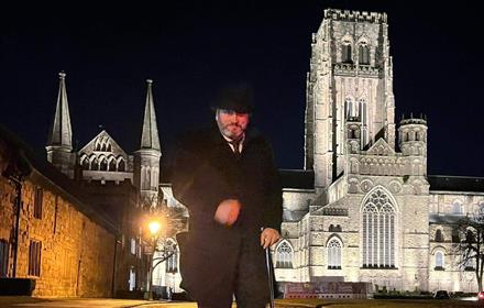 Andrew Ross (Tour guide) standing in front of Durham Cathedral on an evening